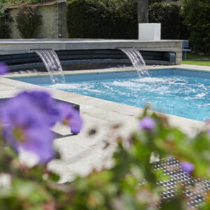 Piscine familiale équipée pour profiter de bons moments en famille. Abri Outdoor avec cascades intégrées.