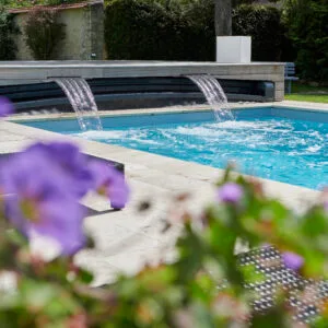 Piscine familiale équipée pour profiter de bons moments en famille. Abri Outdoor avec cascades intégrées.