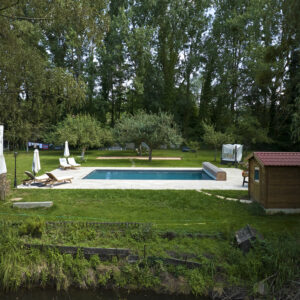 Rénovation d’une piscine extérieure rectangulaire en harmonie avec le parc de la propriété et son étang privé.