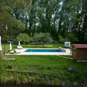 Rénovation d’une piscine extérieure rectangulaire en harmonie avec le parc de la propriété et son étang privé.