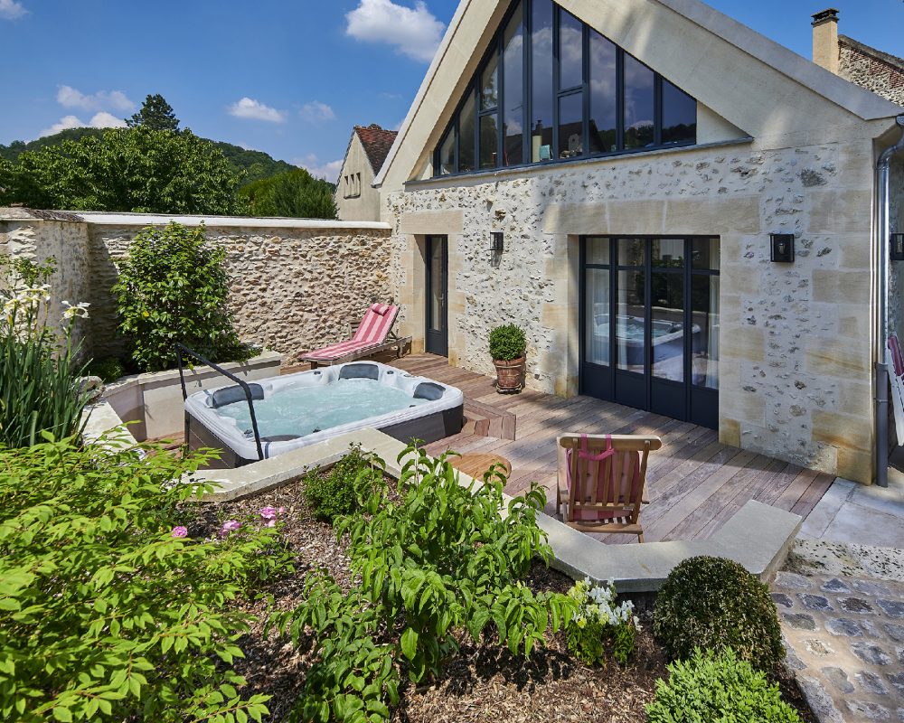 Aménagement d'une espace avec un jardin fleuri et un spa