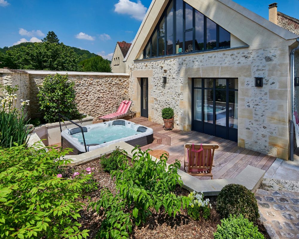 Aménagement d'une espace avec un jardin fleuri et un spa