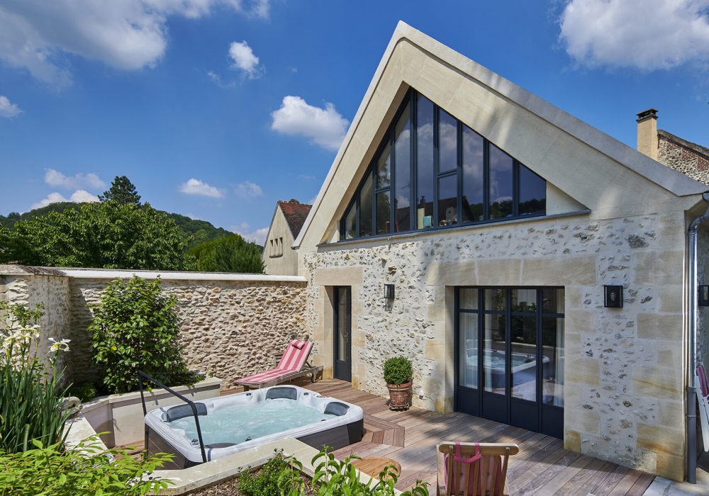 Aménagement extérieur avec un Jacuzzi familial semi encastré sur une terrasse en bois.