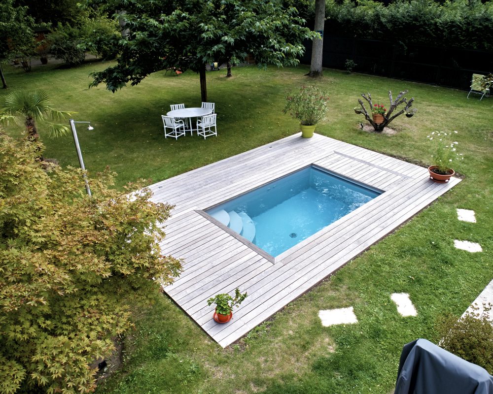 Mini piscine de 4x2,4m avec des margelles en bois exotique et un volet immergé