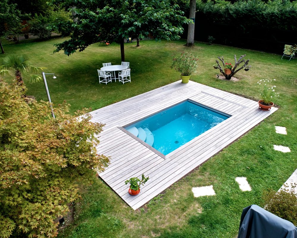 Mini piscine de 4x2,4m avec des margelles en bois exotique et un volet immergé