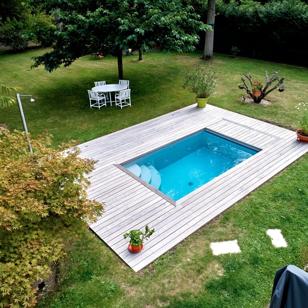 Mini piscine de 4x2,4m avec des margelles en bois exotique et un volet immergé