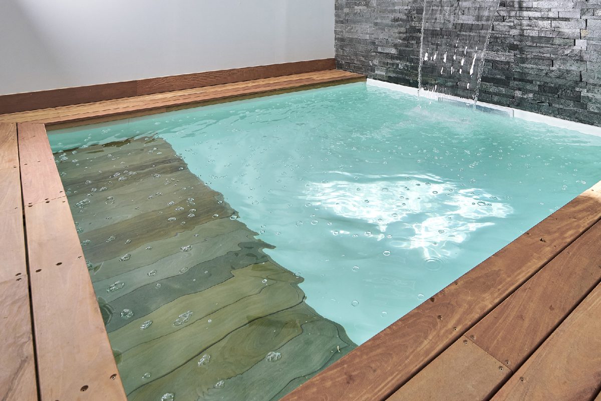 Mini piscine en intérieure avec parement de pierre naturelle et une cascade