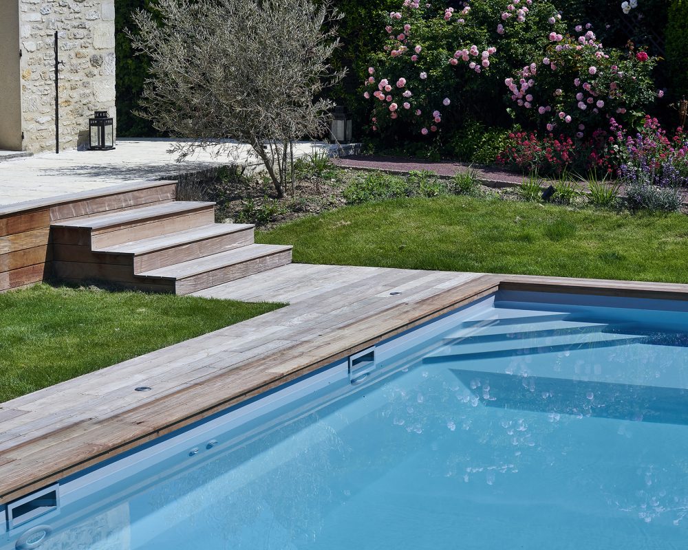 Piscine de 4,5x9,5m avec un liner gris clair et un escalier d'angle