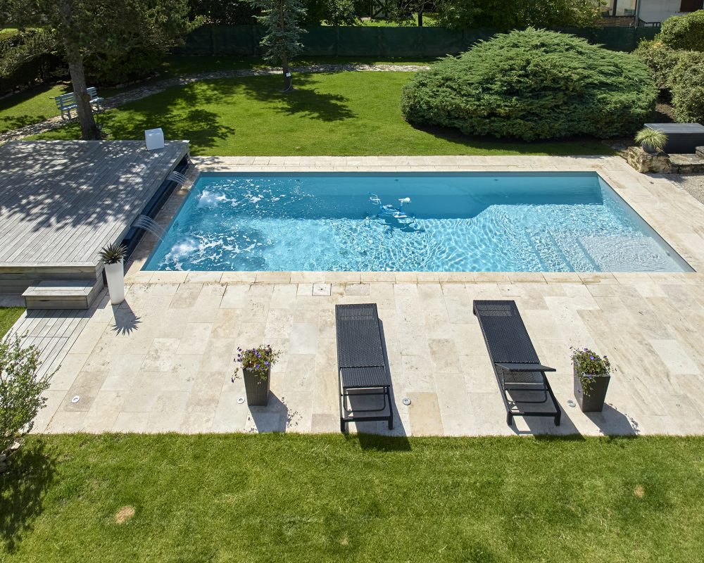 Piscine extérieure familiale de 10x4 m avec margelles et plage en Travertin beige naturel