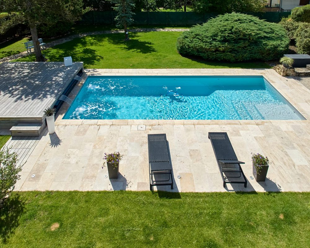 Piscine extérieure familiale de 10x4 m avec margelles et plage en Travertin beige naturel