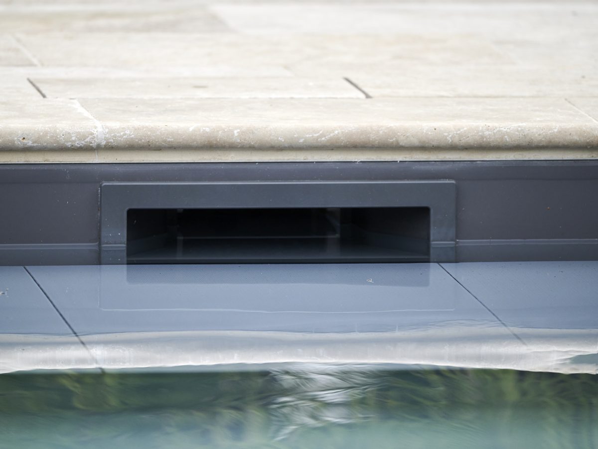 Skimmer d'une piscine avec un liner gris anthracite en travertin beige