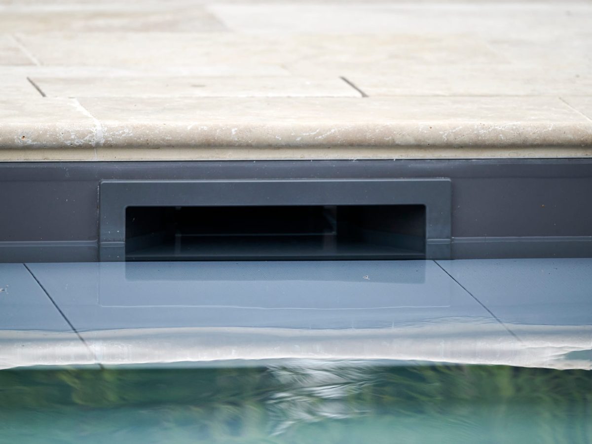 Skimmer d'une piscine avec un liner gris anthracite en travertin beige