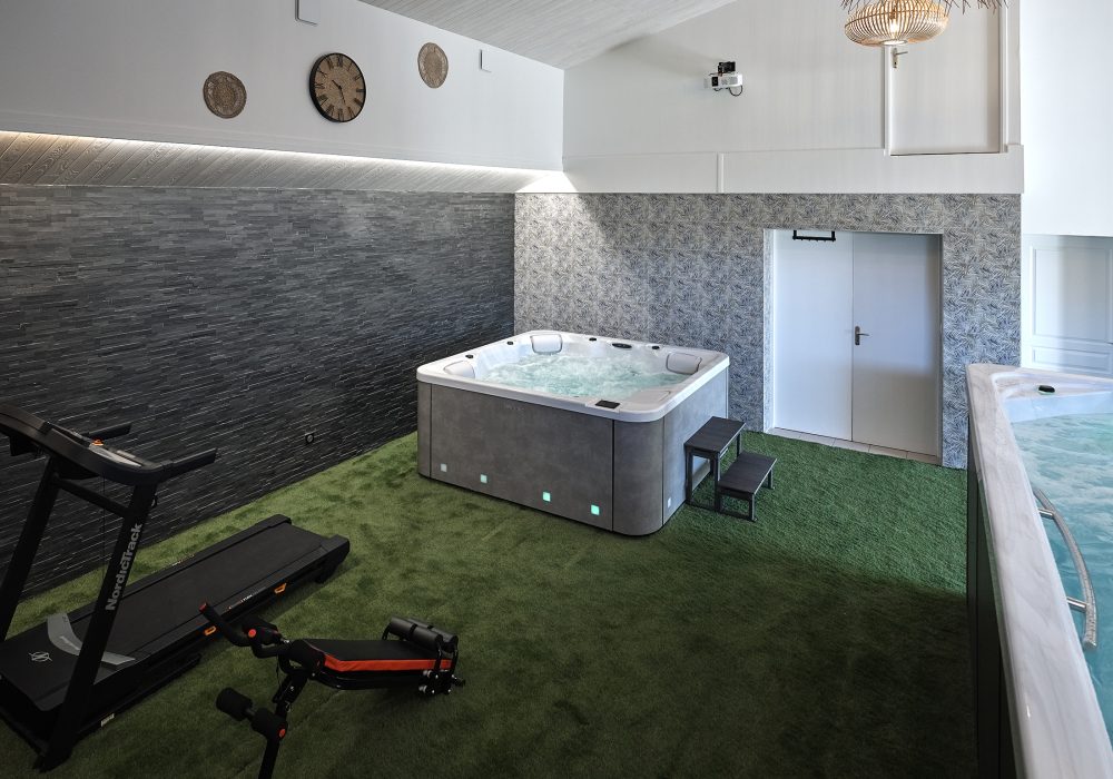 Espace de bien-être intérieur intégrant un jacuzzi et un swimspa.