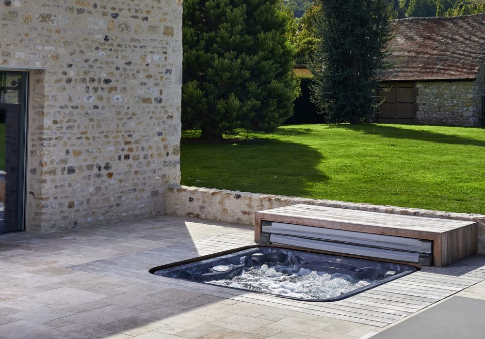 Spa encastré sur terrasse en extérieur, combinant détente et design élégant pour un espace de bien-être.