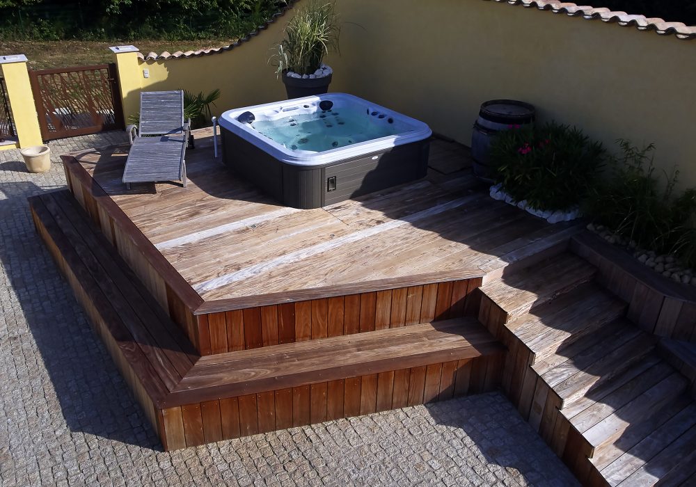 Spa hors sol sur terrasse installé dans un espace bien-être extérieur.