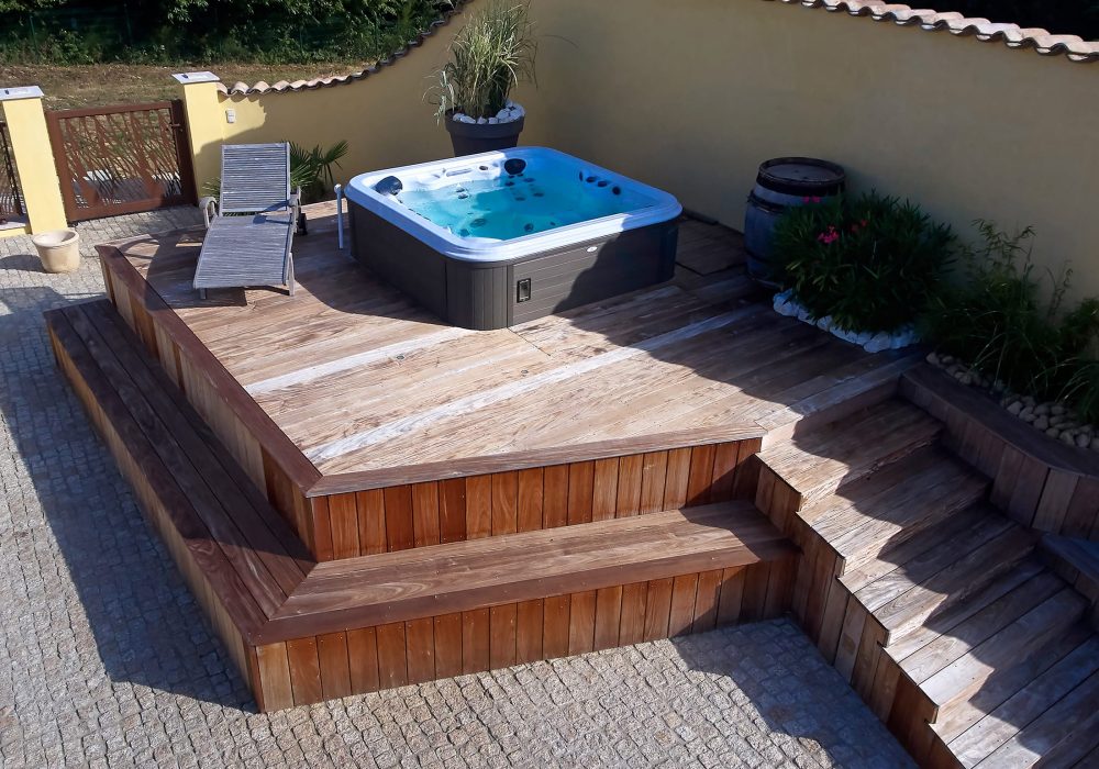 Spa hors sol sur terrasse installé dans un espace bien-être extérieur.
