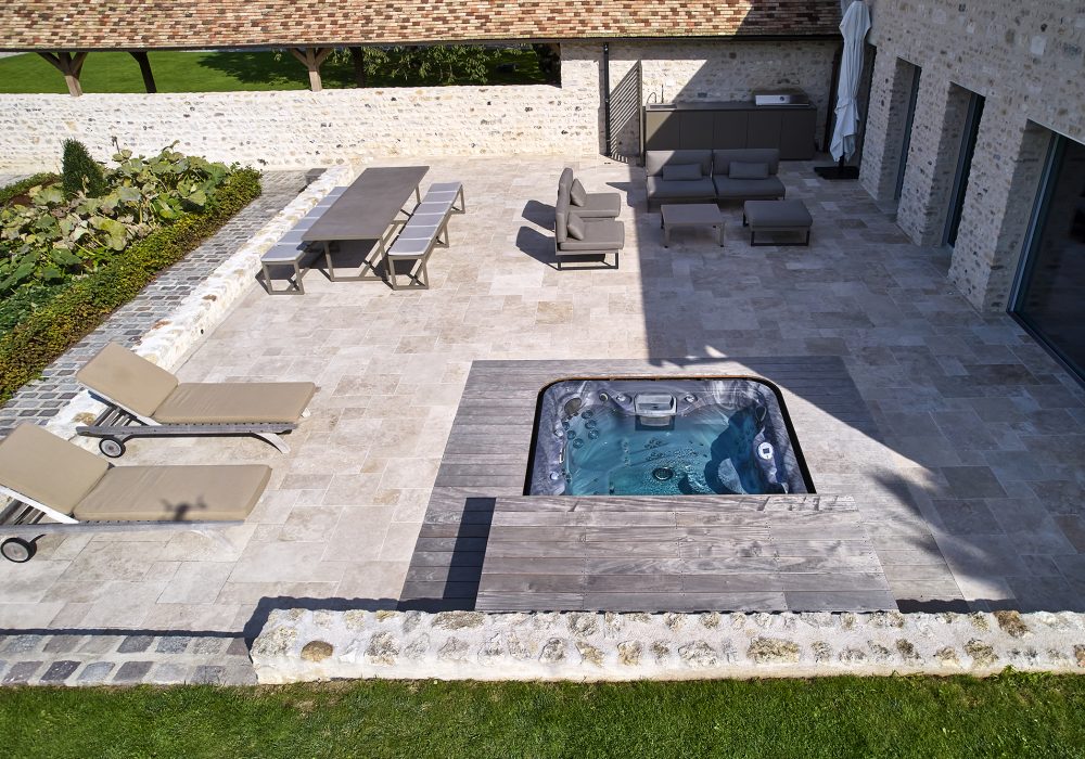 Aménagement extérieur avec spa encastré, idéal pour créer un espace de bien-être.