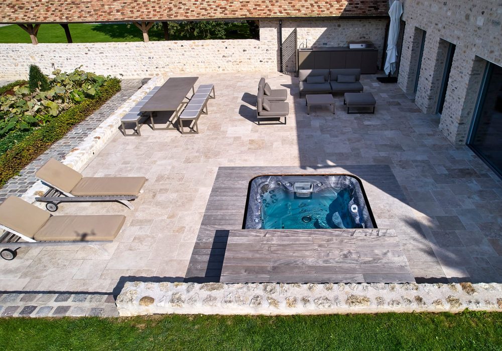 Aménagement extérieur avec spa encastré, idéal pour créer un espace de bien-être.