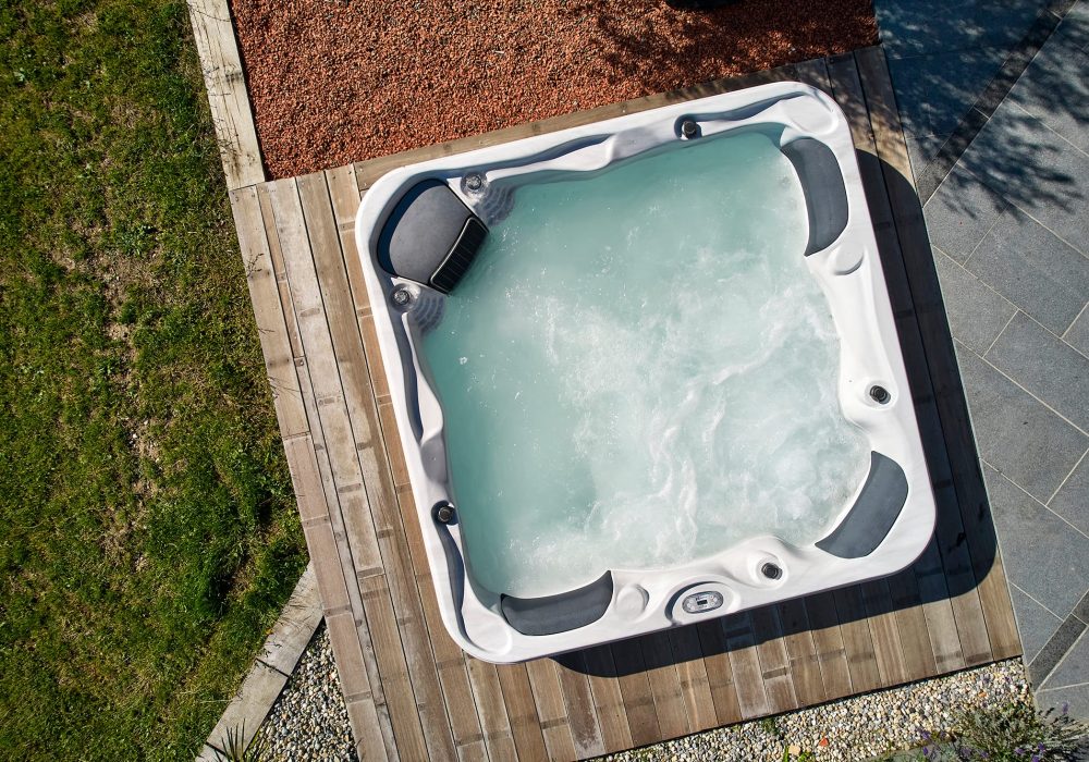 Spa semi-encastré extérieur avec 50 jets de massage, intégré à une terrasse élégante.
